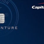 Capital One Venture Rewards credit card shown on a dark blue background, featuring a silver chip on the left, the word ‘Venture’ below it, a subtle airplane and travel-themed pattern in the background, and the Capital One logo in the top-right corner, conveying a premium travel rewards credit card design.